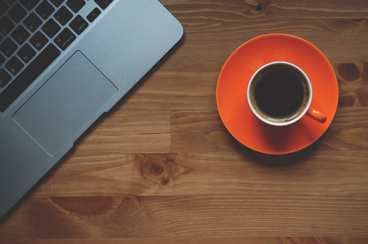 laptop and cup of coffee on a table